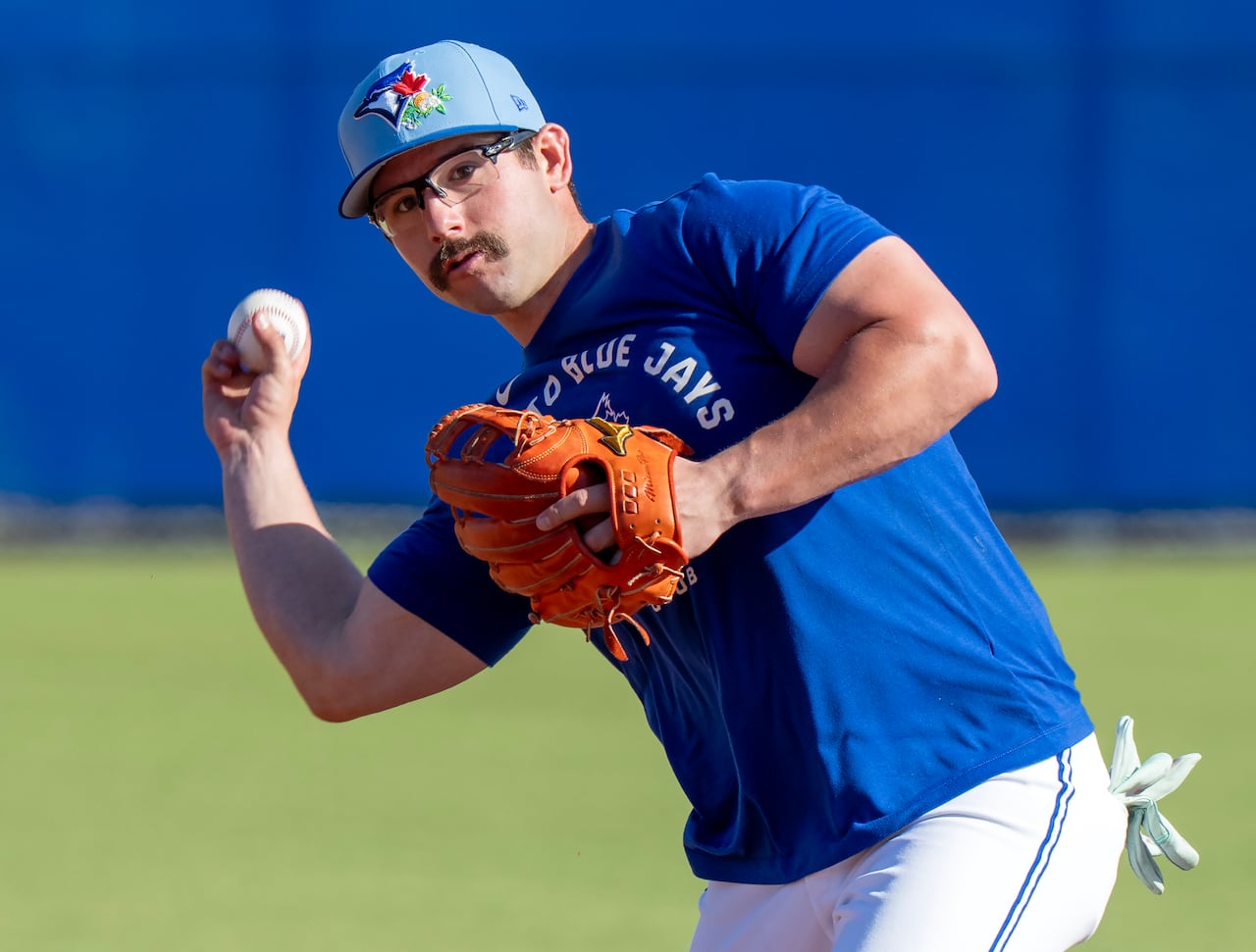 Toronto Blue Jays' David Schneider stands on a baseball field, ready to throw a ball.