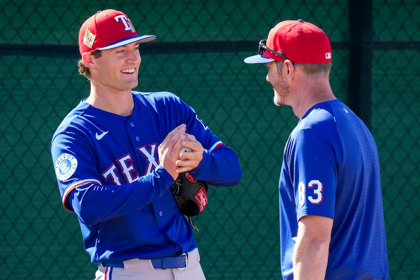 Texas Rangers pitcher Jacob Latz talks with  pitching coach Jordan Tiegs in the bullpen...