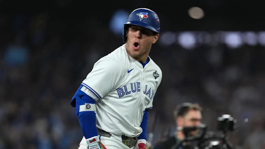 Varsho yells in a white Blue Jays uniform after hitting a home ru