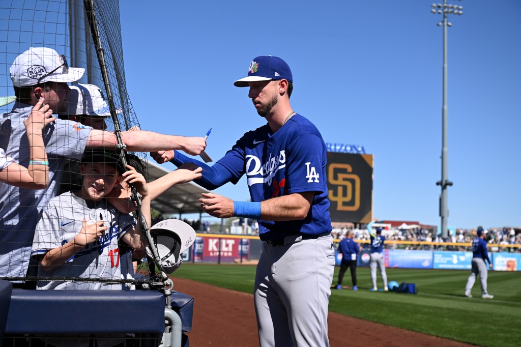 Kyle Tucker of the Los Angeles Dodgers signs autographs for fans.