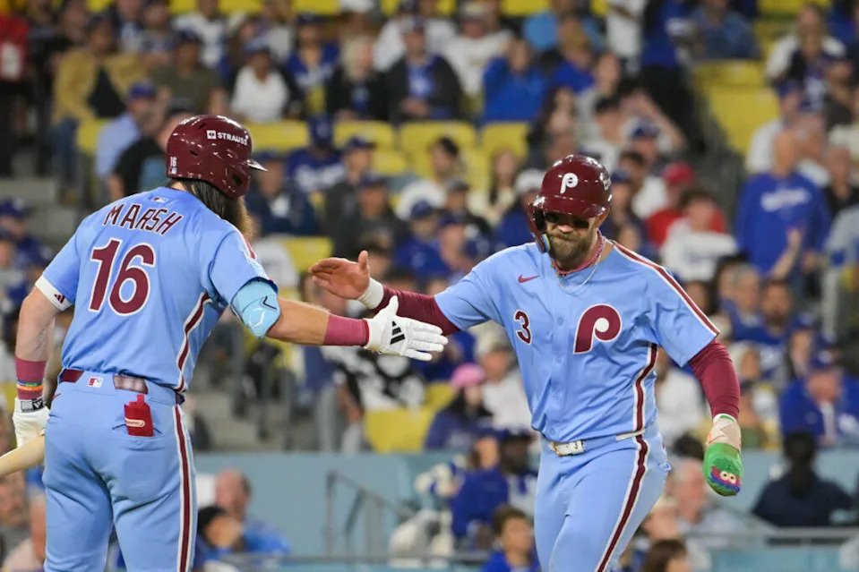 Oct 8, 2025; Los Angeles, California, USA; Philadelphia Phillies first baseman Bryce Harper (3) celebrates with Philadelphia Phillies center fielder Brandon Marsh (16) after scoring on a Los Angeles Dodgers throwing error during the fourth inning during game three of the NLDS round for the 2025 MLB playoffs at Dodger Stadium. Mandatory Credit: Jayne Kamin-Oncea-Imagn Images