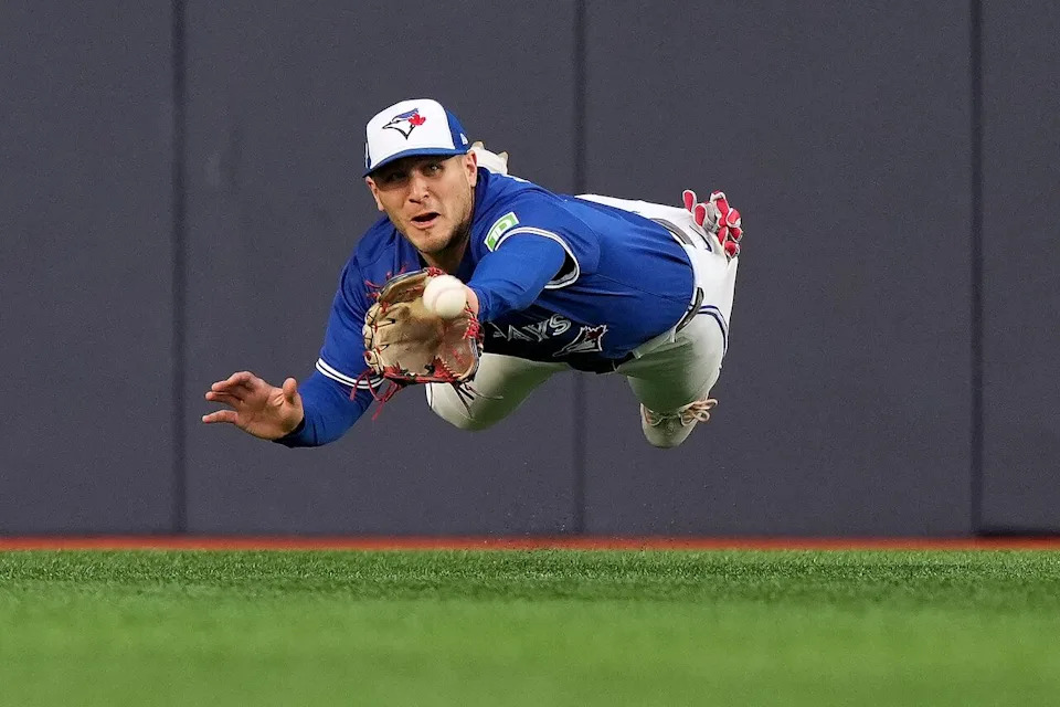 Toronto Blue Jays outfielder Daulton Varsho (5) makes a catch to out Seattle Mariners third baseman Eugenio Suárez (28) during third inning MLB American League Championship Series game 2 baseball in Toronto, Monday, Oct. 13, 2025. THE CANADIAN PRESS/Nathan Denette
