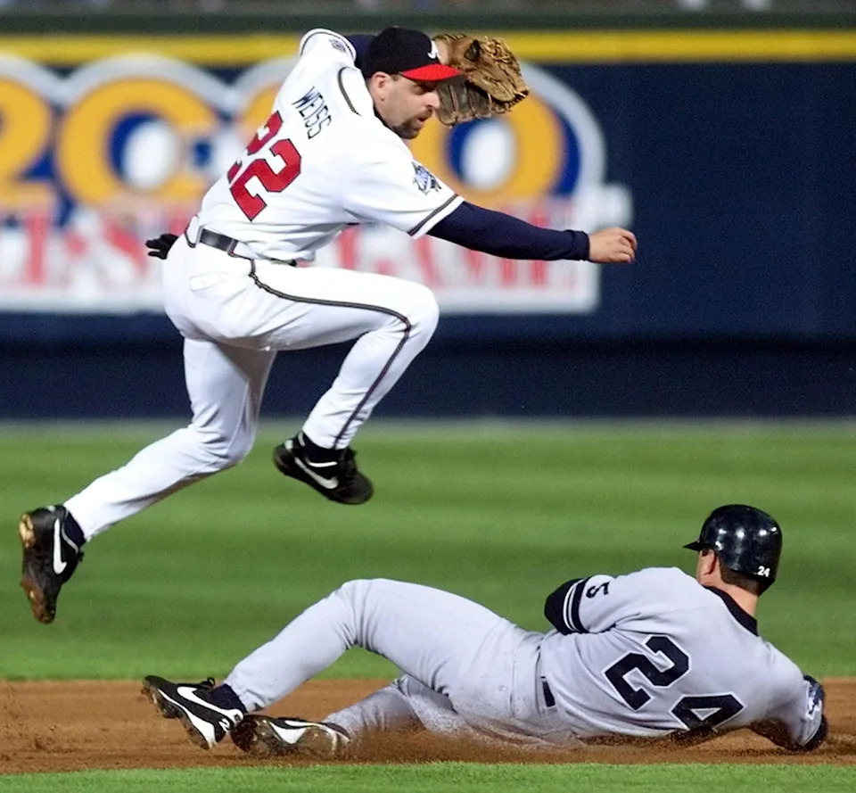 Shortstop Walt Weiss (TOP) of the Atlanta Braves completes a double play over Tino Martinez of the New York Yankees 23 October 1999 during game one of the 1999 World Series at Turner Field in Atlanta, GA. (ELECTRONIC IMAGE) AFP PHOTO/DON EMMERT (Photo by Don EMMERT / AFP) (Photo by DON EMMERT/AFP via Getty Images) | AFP via Getty Images