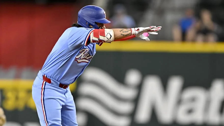 Texas Rangers right fielder Alejandro Osuna flashes his hands at his dugout in celebration