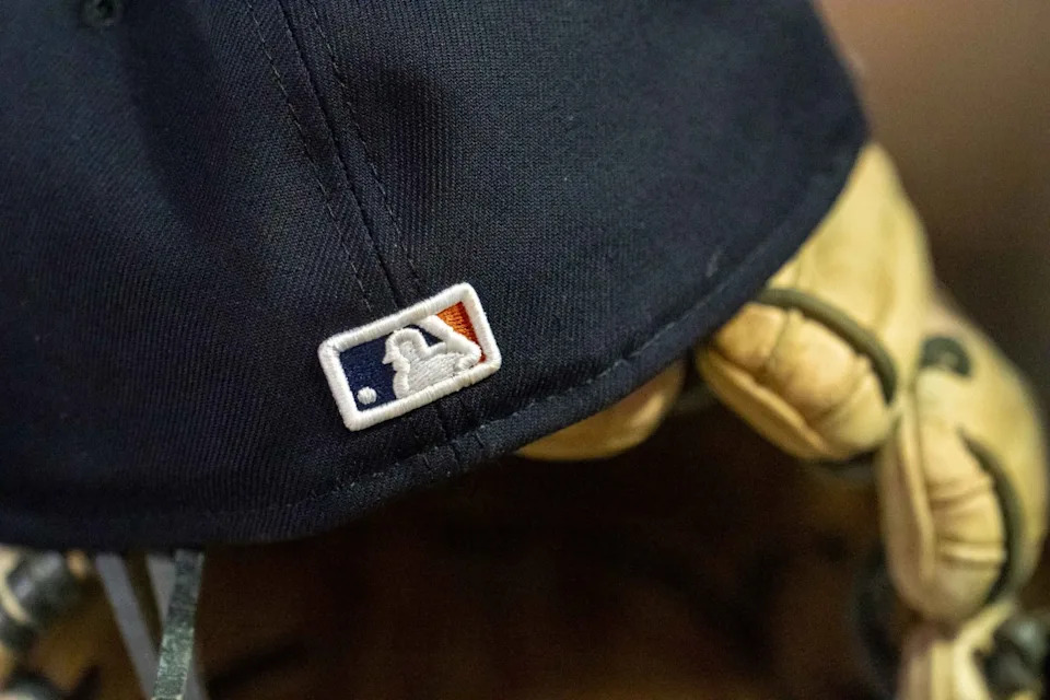 A general view of a Detroit Tigers hat with the Major League Baseball logo sitting in the dugout in a game against the Minnesota Twins at Target Field. Credit: Jesse Johnson-Imagn Images