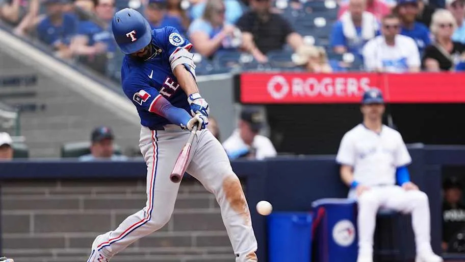Texas Rangers Marcus Semien swinging a baseball bat toward a baseba