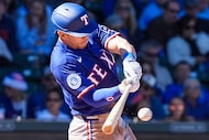 Texas Rangers second baseman Sam Haggerty drives in a run with a single during the second...