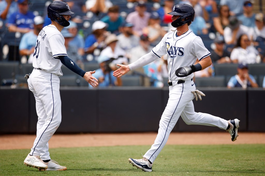 Carson Williams of the Tampa Bay Rays is congratulated after scoring a run.