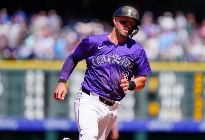 Colorado Rockies second base Kyle Farmer (6) heads home to score a run in the fourth inning against the Chicago Cubs at Coors Field.