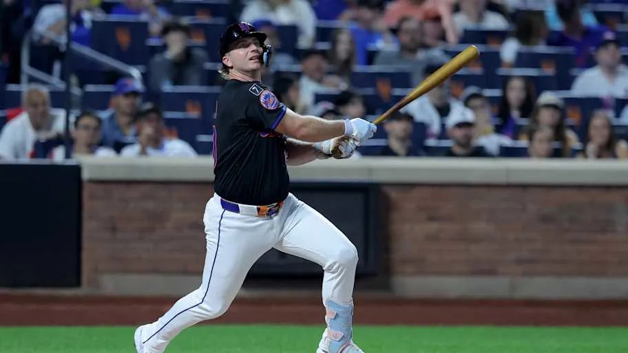 Pete Alonso in a black Mets jersey hitting the bal