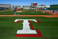 Groundskeepers prepare the field before a spring training game between the Kansas City...