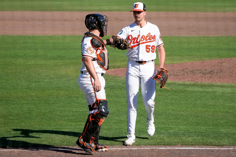 Baltimore Orioles pitcher Chayce McDermott (59) high fives catcher Maverick Handley (98) after striking out the last batter in the seventh inning of a Spring Training game against the Pittsburgh Pirates at Ed Smith Stadium in Sarasota, Fla., on Saturday, February 21, 2026.