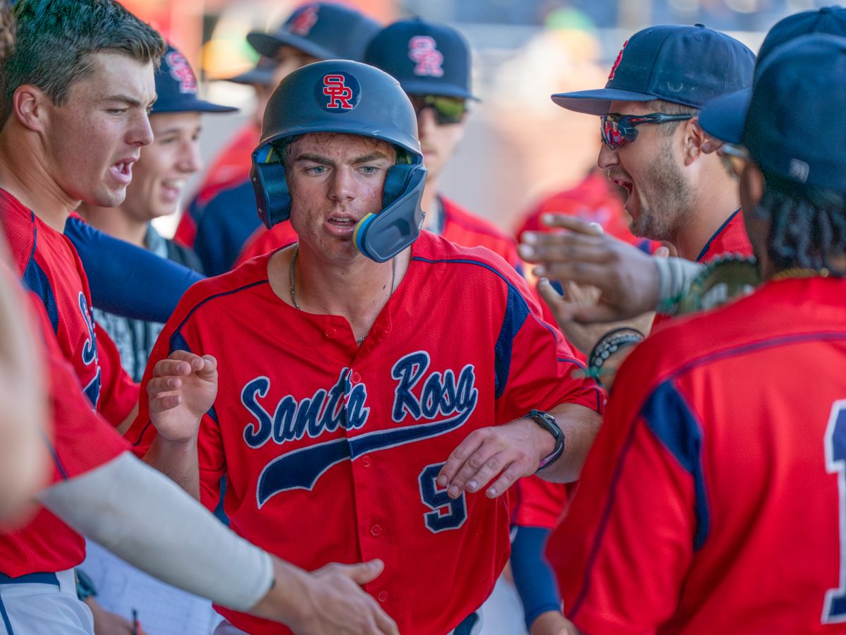 Sophomore Will Tokar is met with high fives in the dugout after a ground ball scored him in to get the Bear Cubs on the board against Cañada College on Friday, Feb. 6 at home.