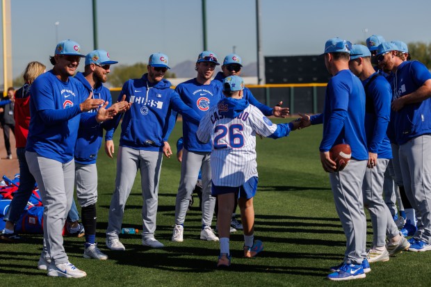 Cubs players clap for Anthony Castaldo, 12, an Advocate Children's Hospital patient, after he signed a one-day contract during spring training at Sloan Park on Feb. 19, 2026, in Mesa, Ariz. (Armando L. Sanchez/Chicago Tribune)