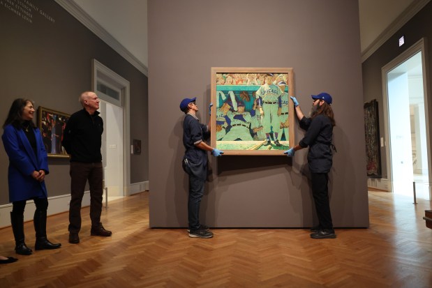 Former Illinois governor Bruce Rauner, second left, and his wife, Diana, watch as Norman Rockwell's painting titled "The Dugout" is installed at the Art Institute on Feb. 10, 2026. The painting was gifted to the museum by the Rauners, who have had it hanging in their home for the past 19 years. (Brian Cassella/Chicago Tribune)