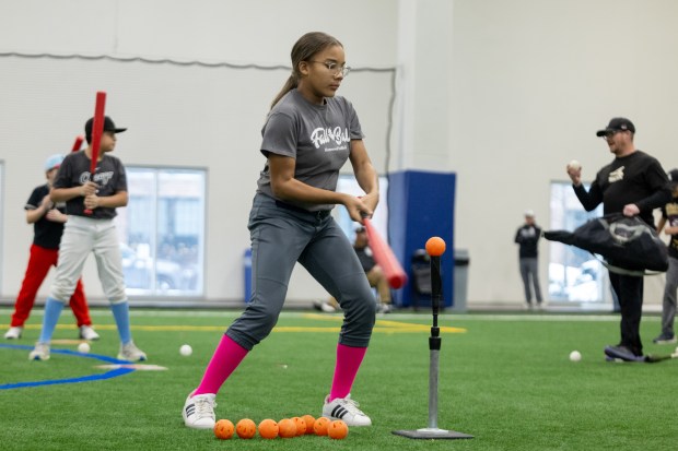 A young girl hits a ball off a batting tee during the Chicago White Sox SoxFest Kids Camp Saturday, Jan. 31, 2026, at the ComEd Recreation Center at Addams Park in Chicago. The event allowed kids to learn baseball from youth academy coaches and current White Sox players and prospects. (Josh Boland/Chicago Tribune)