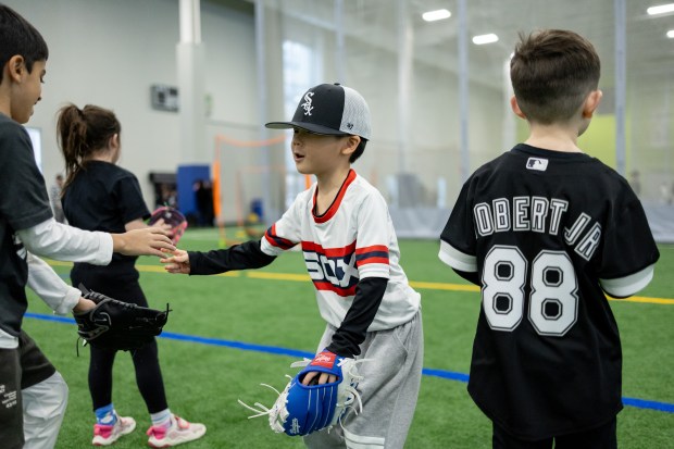 Young baseball players high-five one another during SoxFest Kids Camp at the ComEd Recreation Center at Addams Park in Chicago on Saturday, Jan. 31, 2026. (Josh Boland/Chicago Tribune)