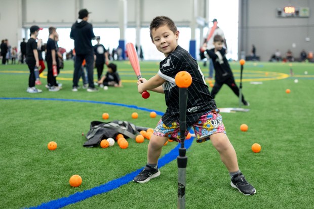 Nolan Bencriscutto, of Arlington Heights, prepares to swing at a ball on a batting tee during the Chicago White Sox SoxFest Kids Camp Saturday, Jan. 31, 2026, at the ComEd Recreation Center at Addams Park in Chicago. The event allowed kids to learn baseball from youth academy coaches and current White Sox players and prospects. (Josh Boland/Chicago Tribune)
