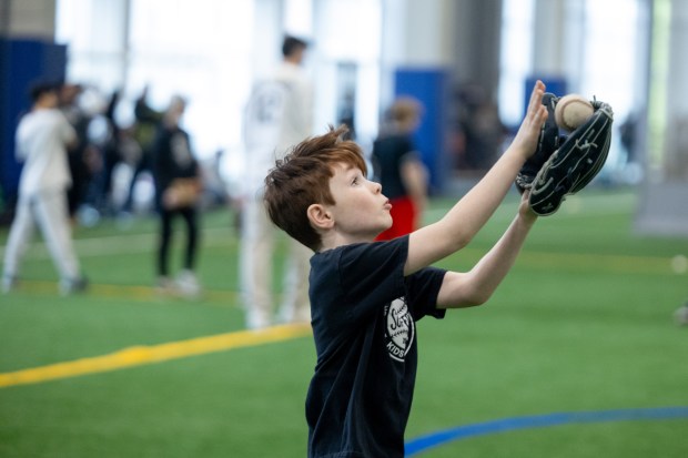 A young boy catches a fly ball during the Chicago White Sox SoxFest Kids Camp Saturday, Jan. 31, 2026, at the ComEd Recreation Center at Addams Park in Chicago. The event allowed kids to learn baseball from youth academy coaches and current White Sox players and prospects. (Josh Boland/Chicago Tribune)