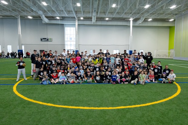 Participants, coaches, and Chicago White Sox players pose for a photo during the Chicago White Sox SoxFest Kids Camp Saturday, Jan. 31, 2026, at the ComEd Recreation Center at Addams Park in Chicago. The event allowed kids to learn baseball from youth academy coaches and current White Sox players and prospects. (Josh Boland/Chicago Tribune)