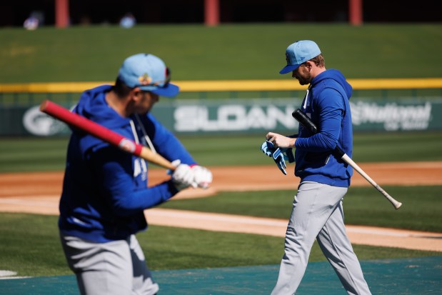 Cubs outfielders Seiya Suzuki, left, and Ian Happ walk on the field during batting practice at spring training on Feb. 19, 2026, at Sloan Park in Mesa, Ariz. (Armando L. Sanchez/Chicago Tribune)