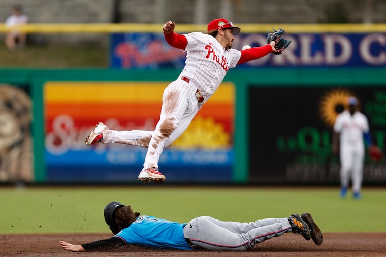 Philadelphia Phillies second baseman Bryson Stott flies over Miami Marlins third baseman Connor Norby as Norby steals second base during the second inning.