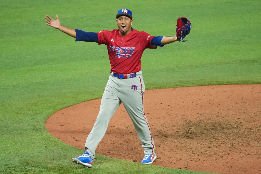 Baseball player celebrating with arms outstretched.