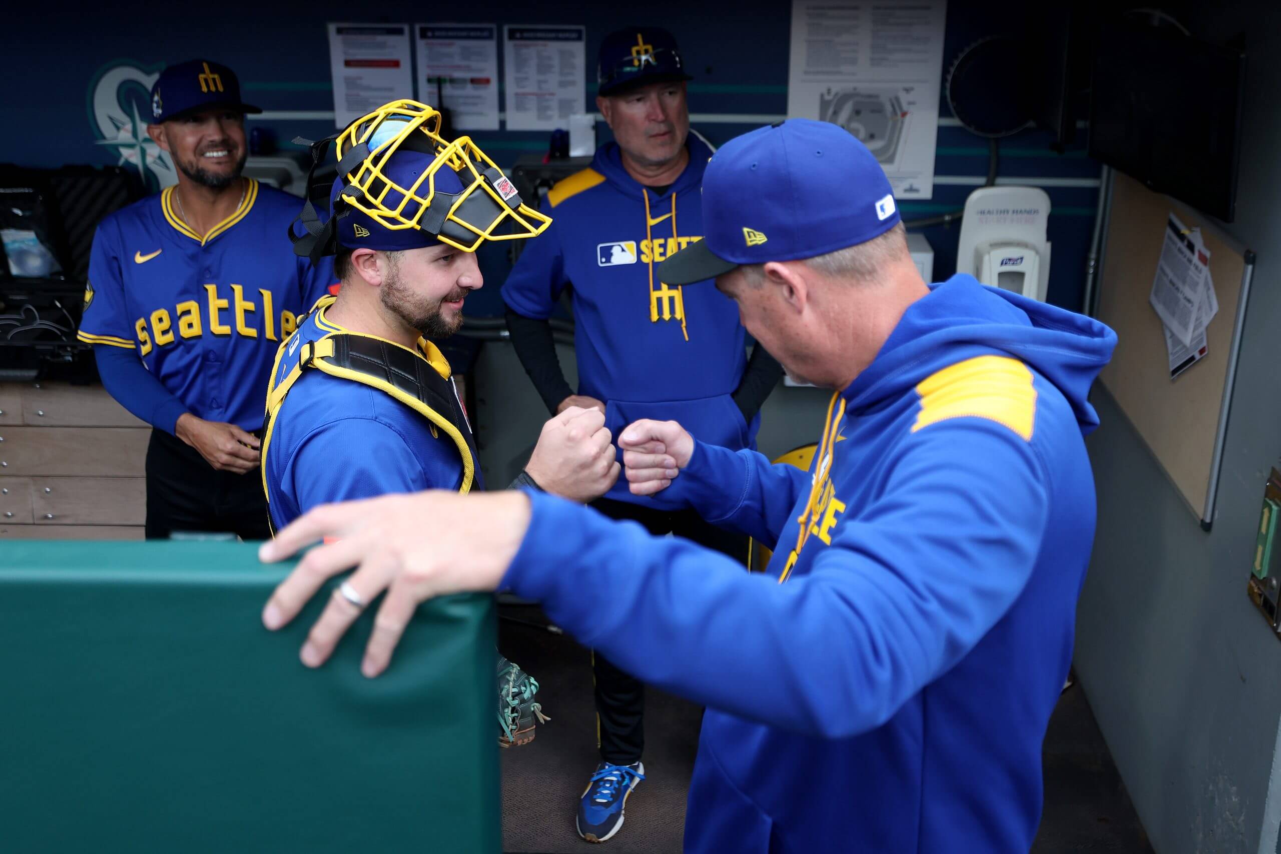 Cal Raleigh and Dan Wilson fist bump before a game at T-Mobile Park