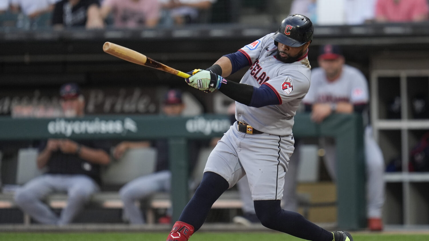 Cleveland Guardians' Carlos Santana hits a two-run double during the first inning of a baseball gam...