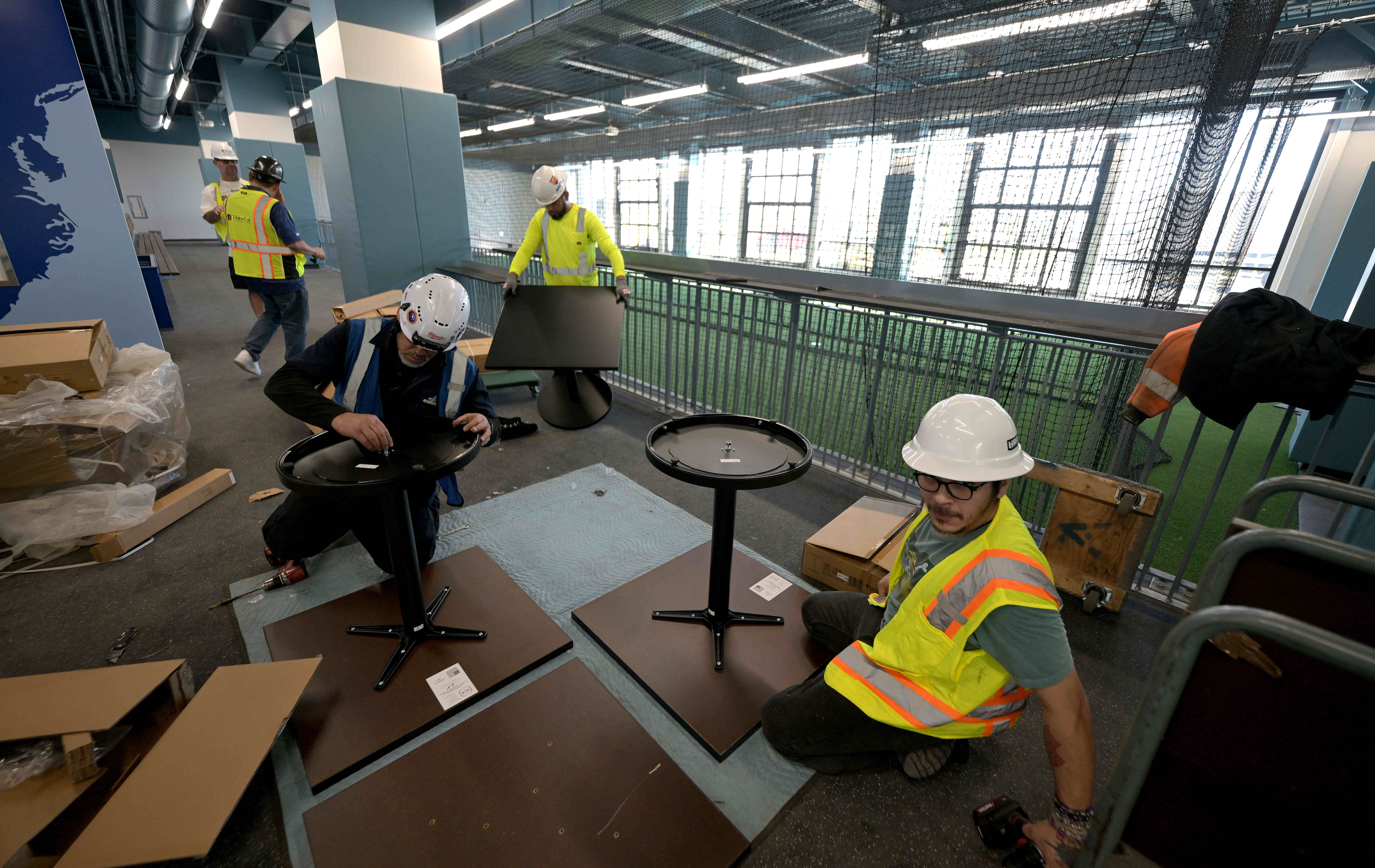 Workers assemble tables and chairs Friday, Feb. 13, 2026, in...