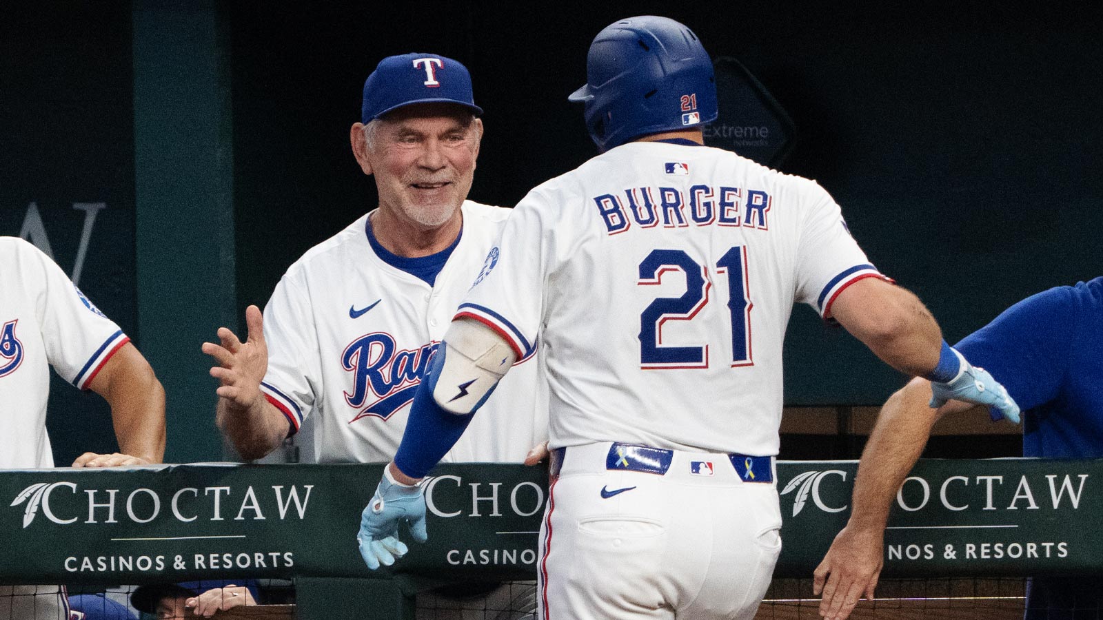 Texas Rangers first baseman Jake Burger (21) celebrates his two-run home run with manager Bruce Bochy (15) against the Milwaukee Brewers during the fifth inning at Globe Life Field. 