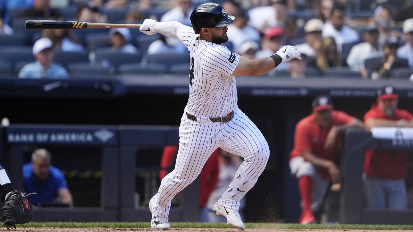 New York Yankees left fielder Jasson Dominguez (24) hits an infield single against the Washington Nationals during the third inning at Yankee Stadium.
