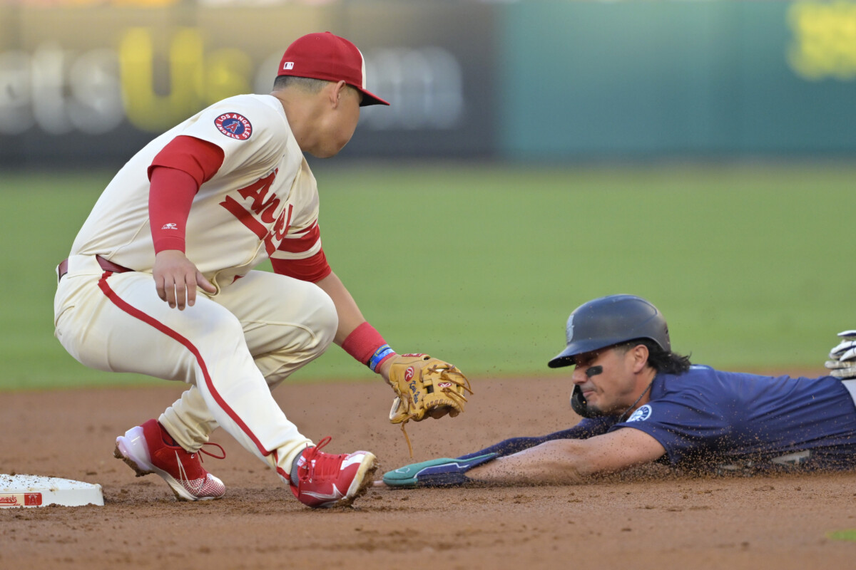 Josh Rojas #4 of the Seattle Mariners is caught stealing on tag by Keston Hiura #13 of the Los Angeles Angels in the second inning at Angel Stadium.