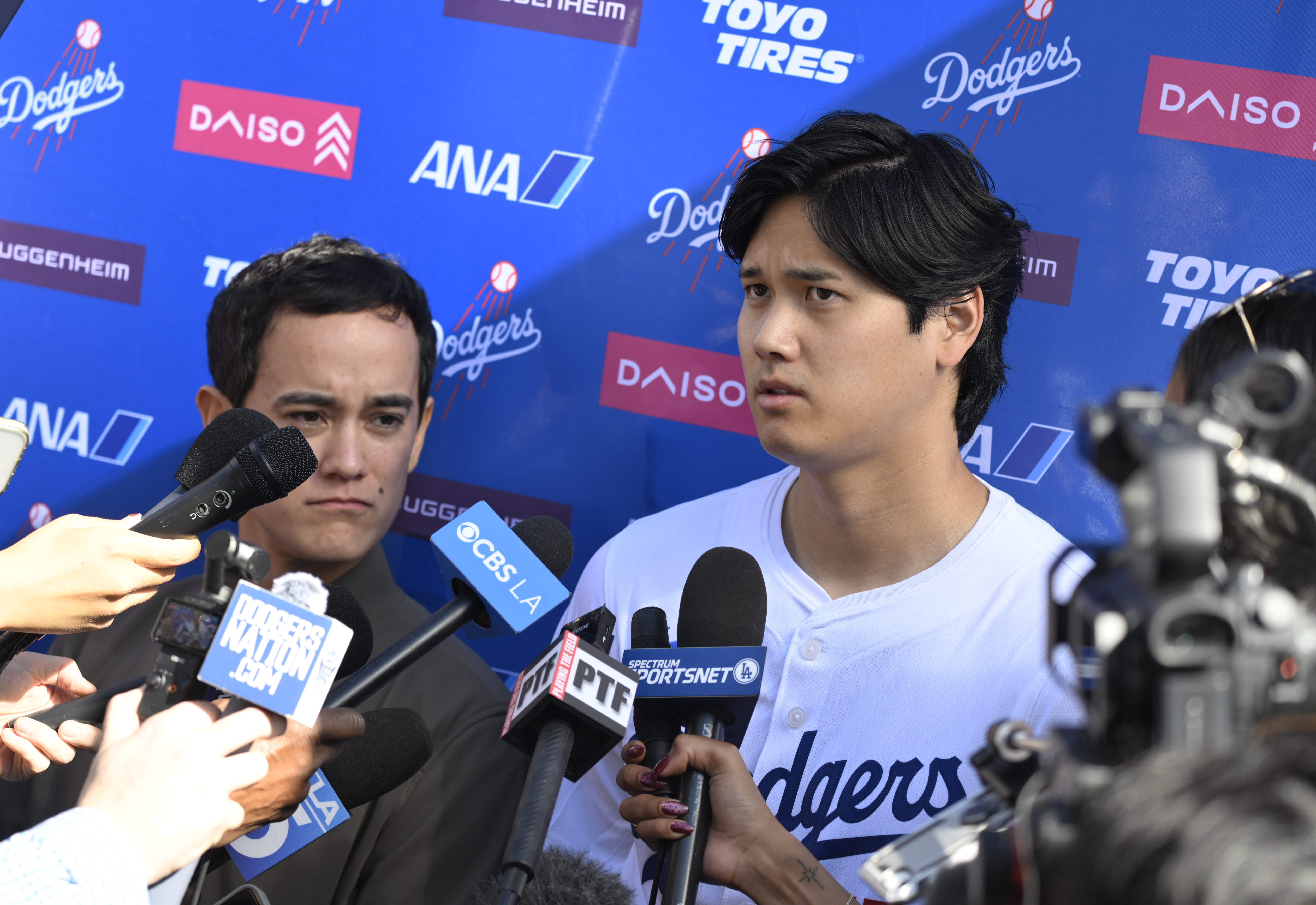 Dodgers star Shohei Ohtani, right, with the help of interpreter...
