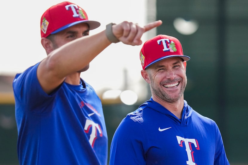 Texas Rangers manager Skip Schumaker (right) laughs with bench coach Luis Urueta during a...