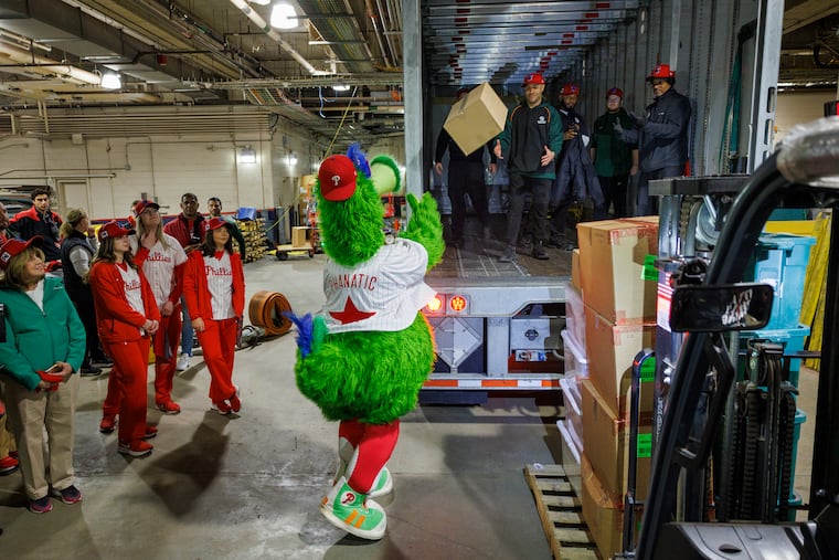Phillie Phanatic tosses a box onto truck at start of loading, spring training supplies. Philadelphia Phillies load up their cargo trucks t transport their equipment and supplies for start of Spring Training in Clearwater, Florida at Citizens Bank Park, Philadelphia, Monday, Feb. 3, 2025.