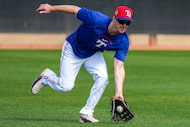 Texas Rangers outfield Mark Canha participates in a fielding drill during a spring training...
