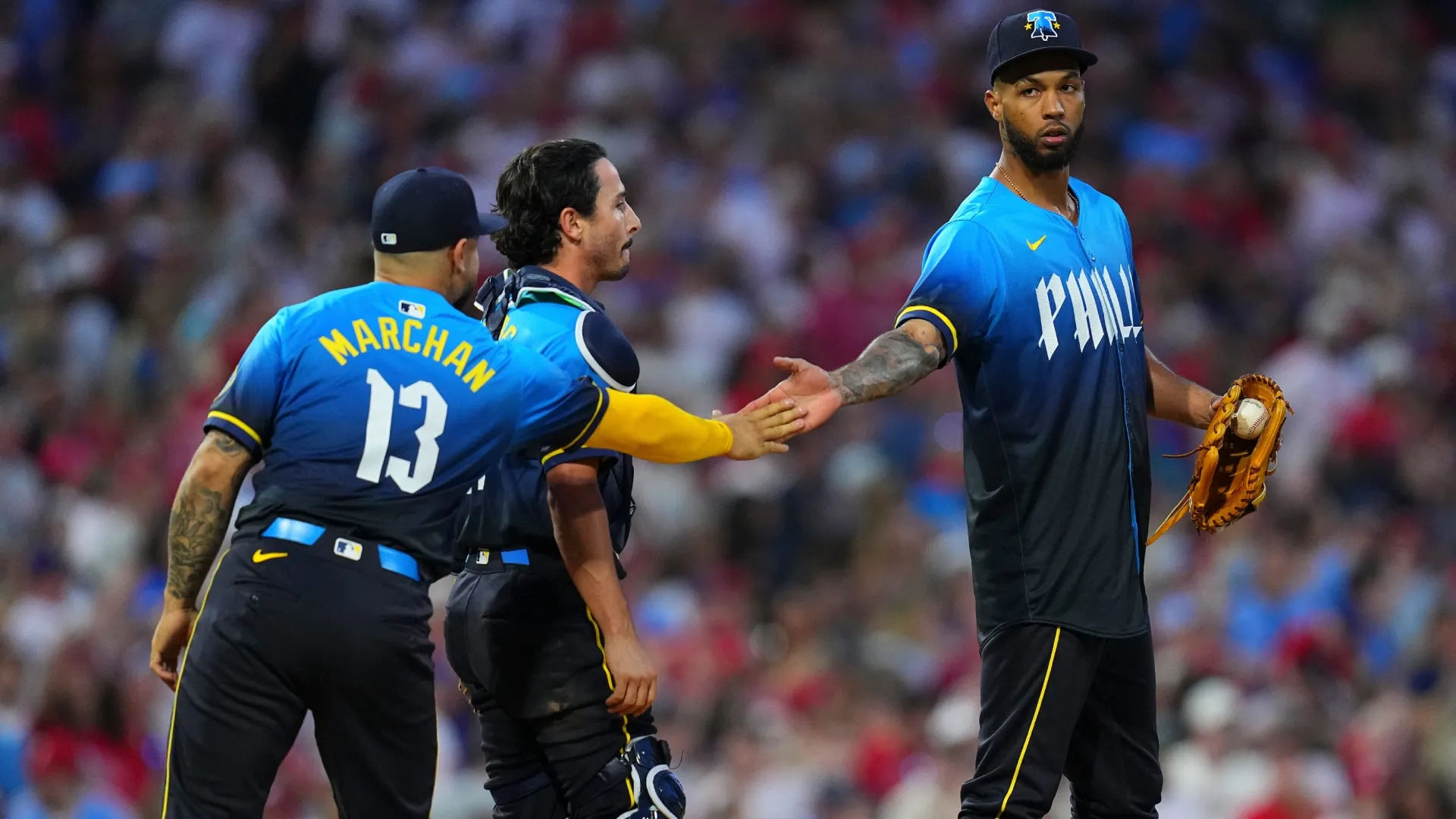 Cristopher Sánchez #61 of the Phillies celebrates with Rafael Marchán #13 and Garrett Stubbs #21 after the game. Mitchell Leff/Getty Images