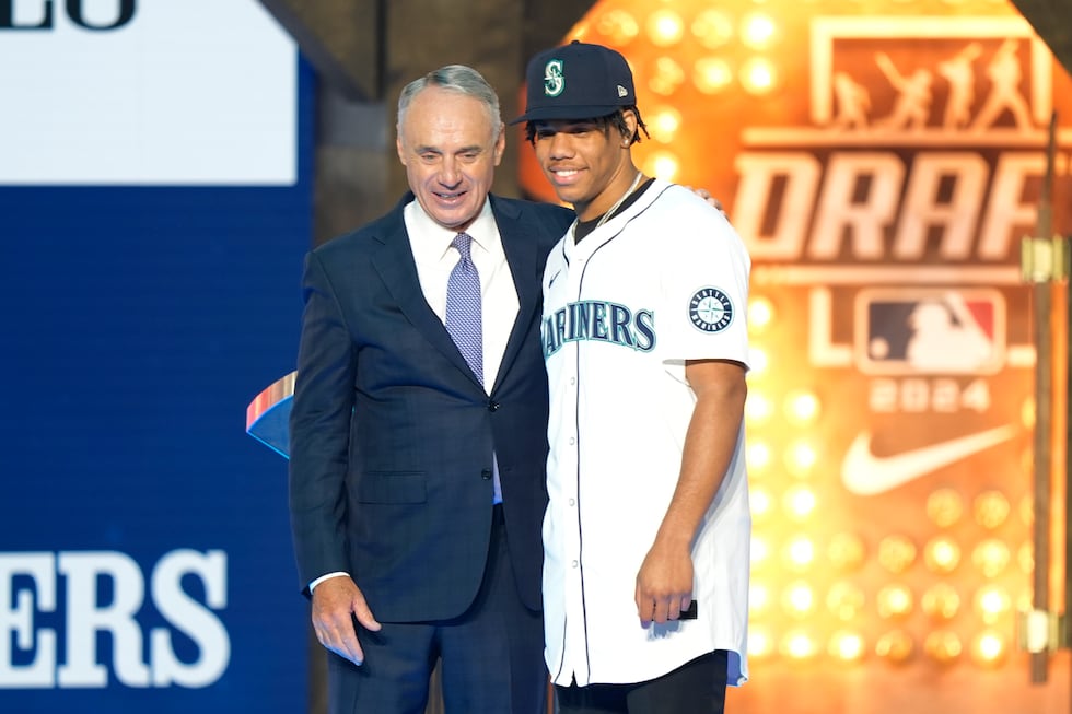Major League Baseball Commissioner Rob Manfred, left, and Jurrangelo Cijntje, pose after...
