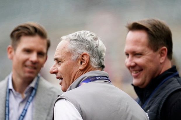 FILE - MLB Commissioner Rob Manfred, center, talks with Twins executive chair Joe Pohlad, left, and president of baseball operations Derek Falvey before Game 2 of an AL wild-card baseball playoff series between the Twins and the Toronto Blue Jays Wednesday, Oct. 4, 2023, in Minneapolis. (AP Photo/Abbie Parr)