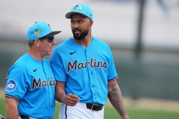 Miami Marlins manager Clayton McCullough, left, talks with pitcher Sandy Alcantara, right, during spring training baseball, Sunday, Feb. 15, 2026, in Jupiter, Fla. (AP Photo/Lynne Sladky)