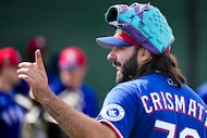 Texas Rangers pitcher Nabil Crismatt laughs with teammates during a spring training workout...