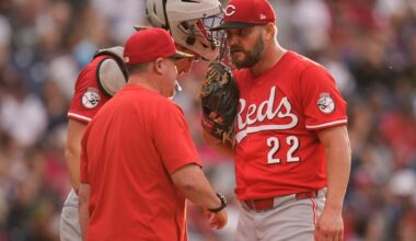 Cincinnati Reds pitching coach Derek Johnson, left, talks with catcher Tyler Stephenson, center, and starting pitcher Wade Miley (22) in the third inning of a baseball game in Cleveland, Monday, June 9, 2025. (AP Photo/Sue Ogrocki)