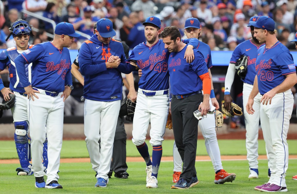 New York Mets pitcher Griffin Canning #46, is helped from the field after getting injured in the 3rd inning.
