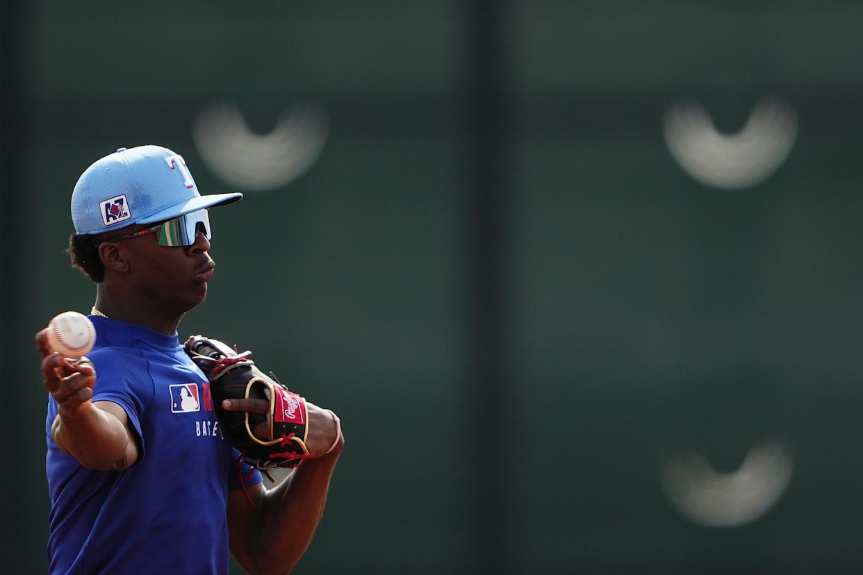 FILE - Texas Rangers infielder Sebastian Walcott throws while running fielding drills during spring training baseball practice at the team's training facility Feb. 17, 2025, in Surprise, Ariz. (AP Photo/Lindsey Wasson, File)