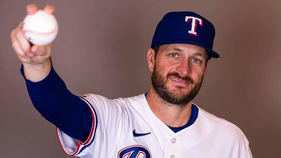 Texas Rangers pitcher Ryan Brasier poses with a baseball for a photo.