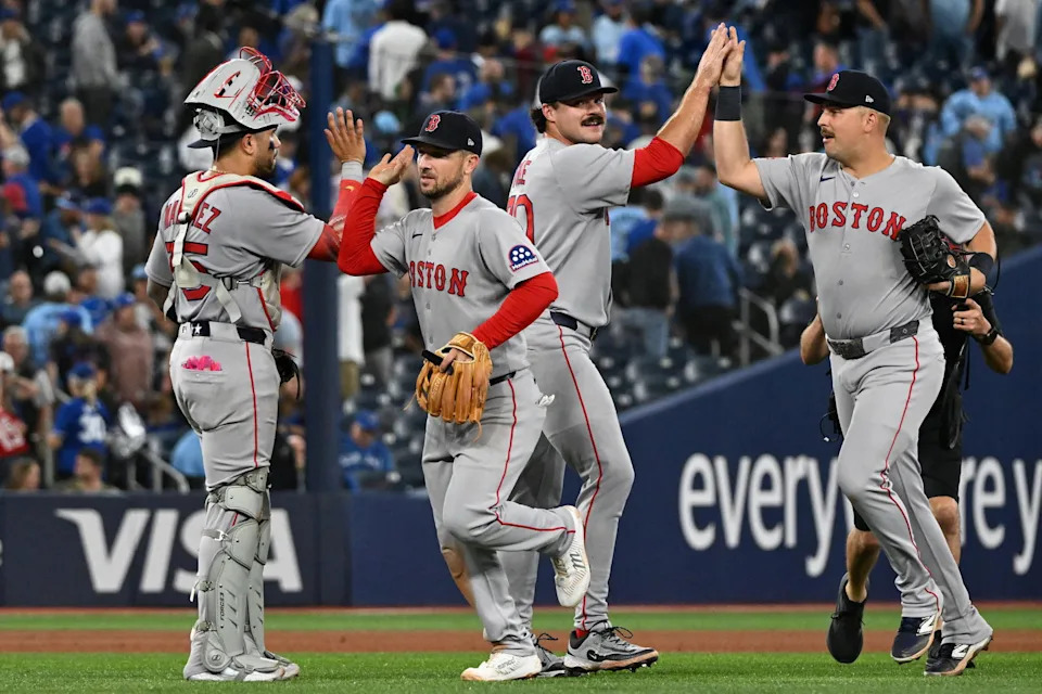 Sep 24, 2025; Toronto, Ontario, CAN; Boston Red Sox catcher Carlos Narvaez (75) celebrates with a win over the Toronto Blue Jays with third baseman Alex Bregman (2) as relief pitcher Payton Tolle (70) slaps hands with first baseman Nathaniel Lowe (37) at Rogers Centre. (Dan Hamilton/Imagn Images)