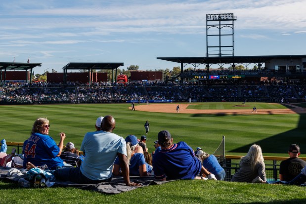 Fans sit behind the outfield as the Chicago Cubs play against the Chicago White Sox in the ninth inning during the Cubs and White Sox first spring training game of the year at Sloan Park Friday Feb. 20, 2026 in Mesa, Ariz. (Armando L. Sanchez/Chicago Tribune)