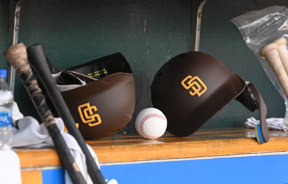 A detailed view of two San Diego Padres batting helmets and a baseball sitting in the dugout during the game against the Detroit Tigers at Comerica Park on July 25, 2022