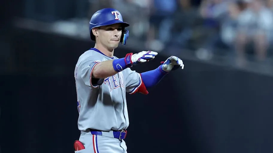 Texas Rangers center fielder Michael Helman points his fingers to the dugout after he reaches second base.